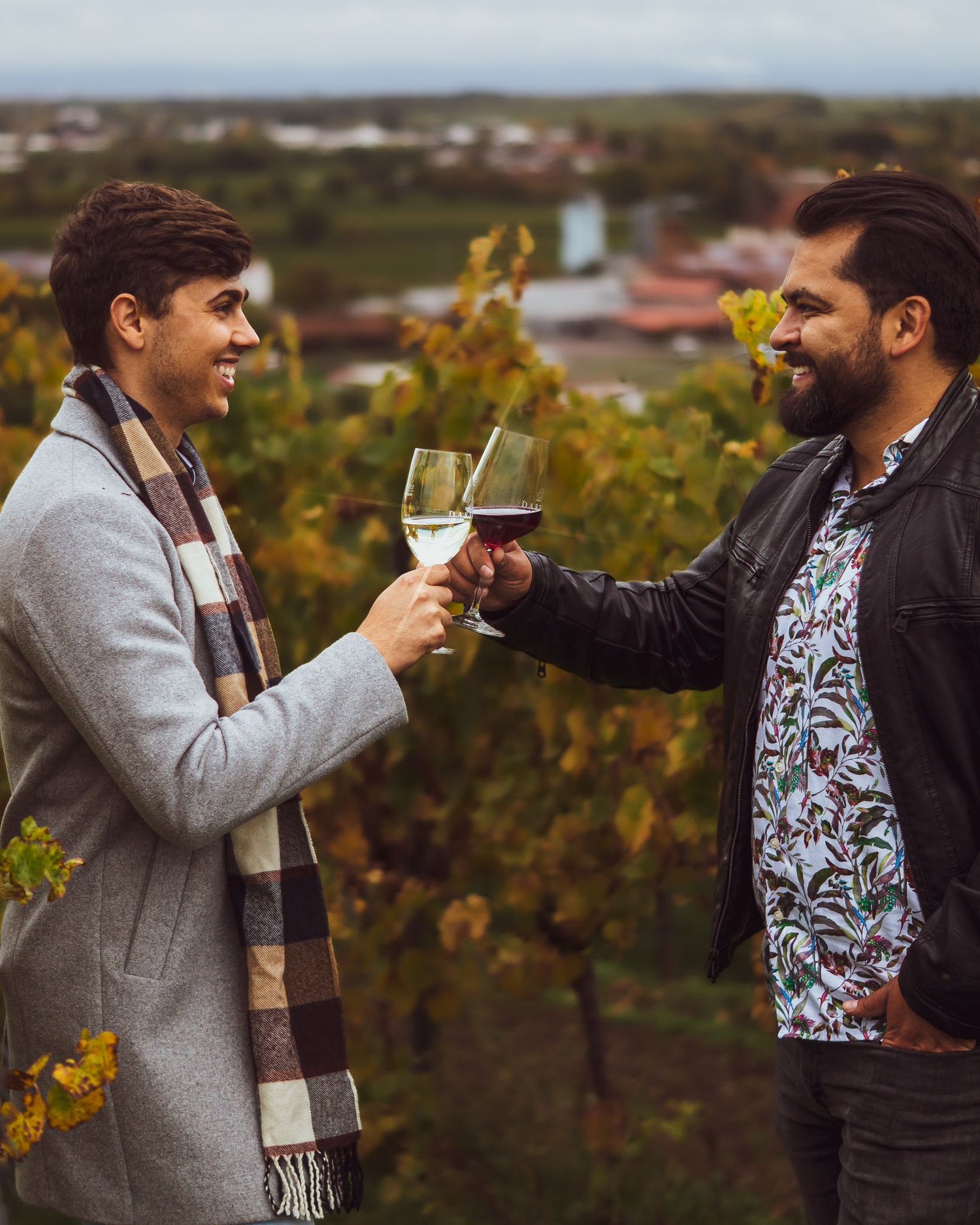 Zwei Männer stoßen mit einem Glas der trockenen Rotweinsorte Pinot Meunier an